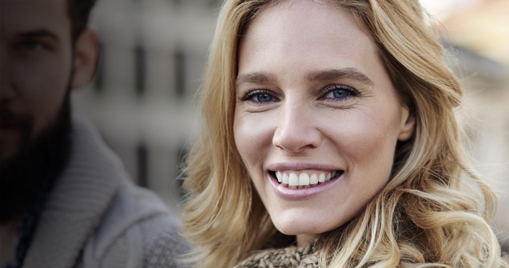 Woman Smiling Closeup with Man at the Back